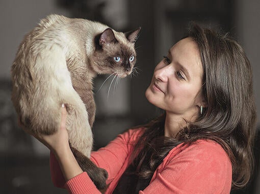 Žena zdvíhajúcu mačku